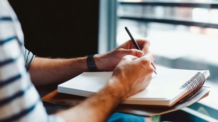Image of a notebook with a person writing notes